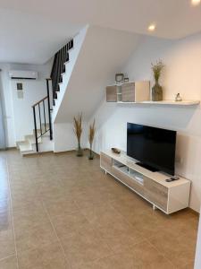 a living room with a television and a staircase at Exclusivo Adosado Jalance in Jalance
