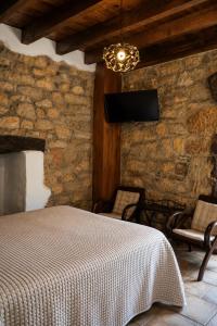 a bedroom with a bed and a stone wall at Posada La Llosa de Viveda - Adults Only in Santillana del Mar