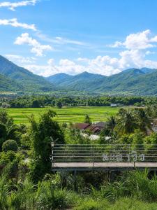 Eine Bank auf einem Feld mit Bergen im Hintergrund in der Unterkunft นะลาวิว รีสอร์ท ปัว Nala View Resort Pua in Pua
