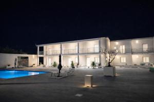 a large building with a swimming pool at night at Omai suite in Ortona