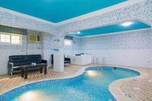 a swimming pool in a room with a couch and a table at شقه الاطلال in Jeddah