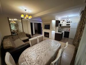 a kitchen and living room with a table and a couch at 3 комнатные апартаменты in Karagandy