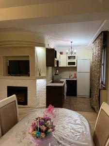 a kitchen and dining room with a table with flowers on it at 3 комнатные апартаменты in Karagandy +4 photos