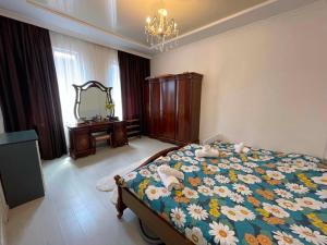 a bedroom with a bed with a floral blanket at Appartaments Anna Kostava in Kobuleti
