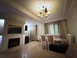 a living room with a fireplace and a dining room at 3 комнатные апартаменты in Karagandy