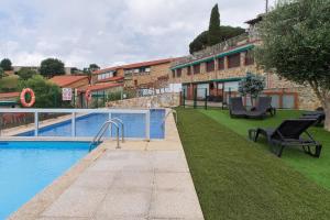 a swimming pool with chairs next to a building at Vivienda Jardin in Monforte de Lemos