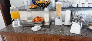 a counter with some juice and a bowl of fruit at HOTEL MORADA DO SOL in Pontal do Paraná