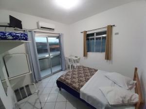 a small bedroom with a bed and a window at HOTEL MORADA DO SOL in Pontal do Paraná