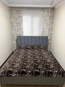 a bedroom with a bed with a blanket on it at 3 комнатные апартаменты in Karagandy