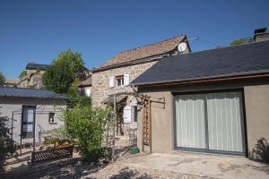 an old stone house with a garage at L'echappée de la lozère in Les Laubies
