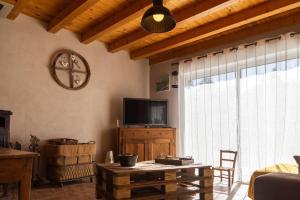 a living room with a television and a table at L'echappée de la lozère in Les Laubies