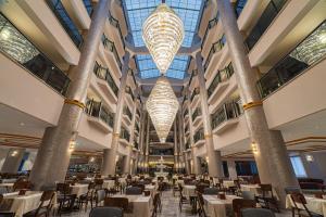 a dining hall with tables and chairs and chandeliers at World Star Beach Resort & Spa in Alanya