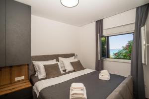 a bedroom with a bed with a large window at Villa Borik in Vrsi +111 photos