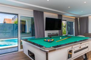 a pool table in a living room with a tv at Villa Borik in Vrsi