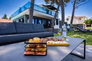 a table with a tray of bread and a glass of wine at Villa Borik in Vrsi
