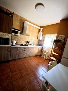a kitchen with wooden cabinets and a tile floor at El Andén del Hueznar in Constantina