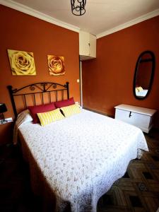 a bedroom with a bed with red walls and a mirror at El Andén del Hueznar in Constantina