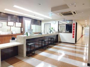 a lobby with a bar with stools and a counter at Kyoto Central Inn in Kyoto