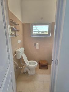 a small bathroom with a toilet and a window at MP Residency Homestay in Munsyari +20 photos