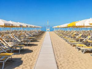 a row of chairs and umbrellas on a beach at Hotel Club I Pini - Boutique Hotel & Residenza d'Epoca in Lido di Camaiore