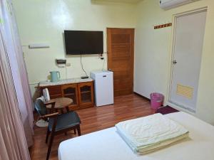 a bedroom with a tv and a bed and a desk at Taitung Moon House in Luye +27 photos