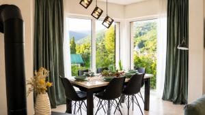 a dining room with a table and chairs and a large window at Vila Atlantida in Velika
