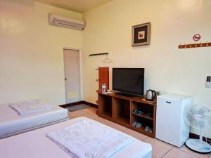 a living room with a television and a refrigerator at Taitung Moon House in Luye