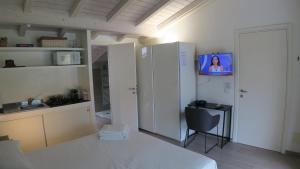 a kitchen with a refrigerator and a chair with a tv at i laghi di Como in Erba