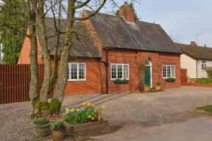 a red brick house with a green door at Red Gables at Pudleston Court in Docklow