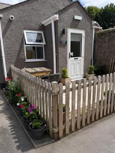 a fence in front of a house with flowers at The Dolphin Hotel & Restaurant in Pembroke Dock
