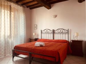 a bedroom with a bed with a red blanket and a window at Affittacamere La Mattonata in Città di Castello