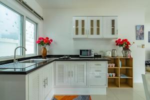 a kitchen with white cabinets and a sink at Chalong - 2 Bedroom Hideaway Private Pool Villa - Phuket in Chalong