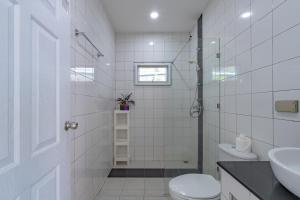 a white bathroom with a toilet and a sink at Chalong - 2 Bedroom Hideaway Private Pool Villa - Phuket in Chalong