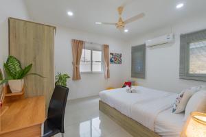 a bedroom with a bed and a desk and window at Chalong - 2 Bedroom Hideaway Private Pool Villa - Phuket in Chalong