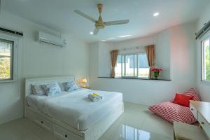 a white bedroom with a bed and a window at Chalong - 2 Bedroom Hideaway Private Pool Villa - Phuket in Chalong