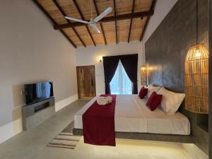a bedroom with a large bed and a television at Villa Nutmeg Grove Galle in Galle
