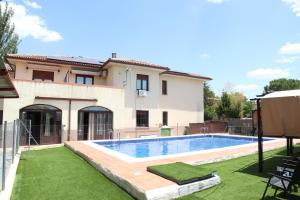 a swimming pool in front of a house at Hostal-Casa Rural Rosa-Nonna in Sigüenza