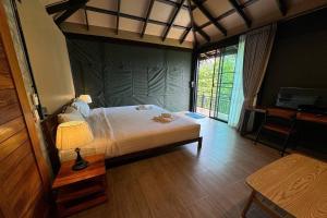 a bedroom with a bed and a table with a lamp at Pha Lae Tawan@Siray in Phuket