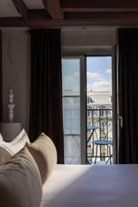 a bedroom with a bed and a view of a balcony at Hôtel Marais Hôme in Paris