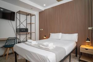 a bedroom with a large bed with towels on it at Ella Torremolinos Centro in Torremolinos
