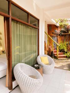 a room with two wicker chairs and a window at Enny's Guest House in Malang