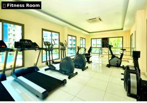 a gym with several treadmills and elliptical machines at Pattaya Laguna Beach Resort 2 in Nong Prue