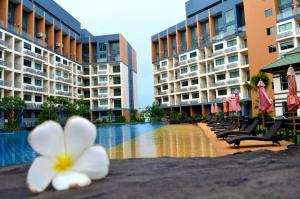 a flower sitting on a table next to a swimming pool at Pattaya Laguna Beach Resort 2 in Nong Prue