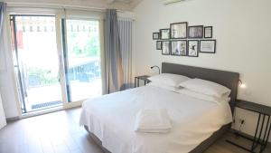 a bedroom with a white bed and a large window at OnSuite With Wiew Near COMO in Erba
