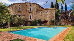 an old building with a swimming pool in front of it at Can Traver de Besalú in Maia de Montcal