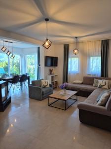 a living room with two couches and a table at Vila Atlantida in Velika