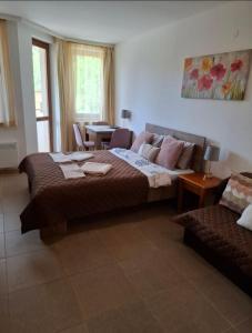 a bedroom with a bed and a couch and a table at Cozy studio 125 in Villa Park in Borovets