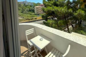 a white table and chairs on a balcony with a window at Zena Hotel Durres in Durrës