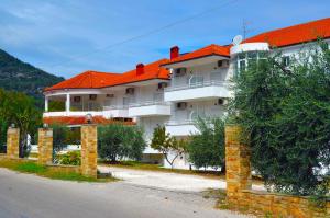 a large white building with an orange roof at Achillion Hotel in Skala Potamias