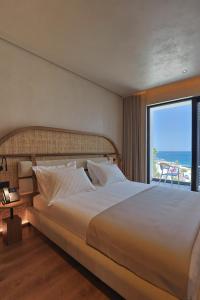 a bedroom with a large bed with a view of the ocean at Hotel Camelot By Artur in Ksamil +75 photos